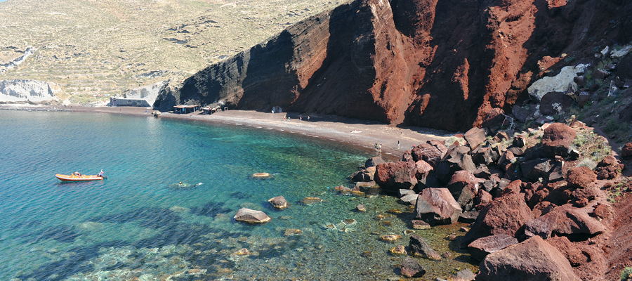 A Praia Vermelha em Santorini, Grécia, tem esse nome devido à coloração de suas rochas